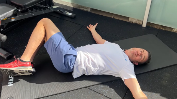 Knees together side-to-side controlled rotation exercise for lower back pain relief”